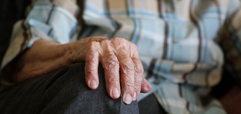 Mano de un anciano apoyada en su rodilla