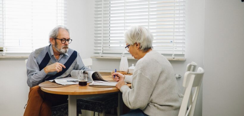 Pareja de señores mayores sentados en una mesa