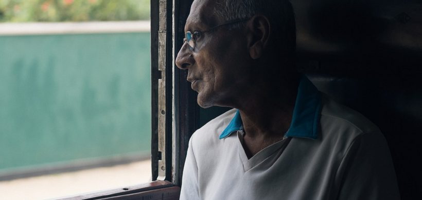 Señor mayor mirando por la ventana