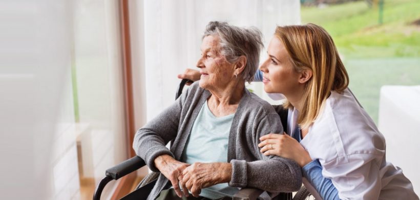 Cuidadora y señora mayor en silla de ruedas