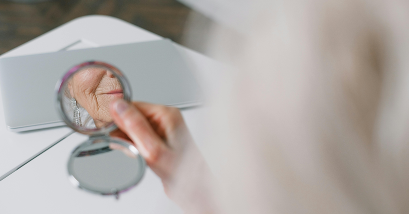 Una mujer se mira en el espejo